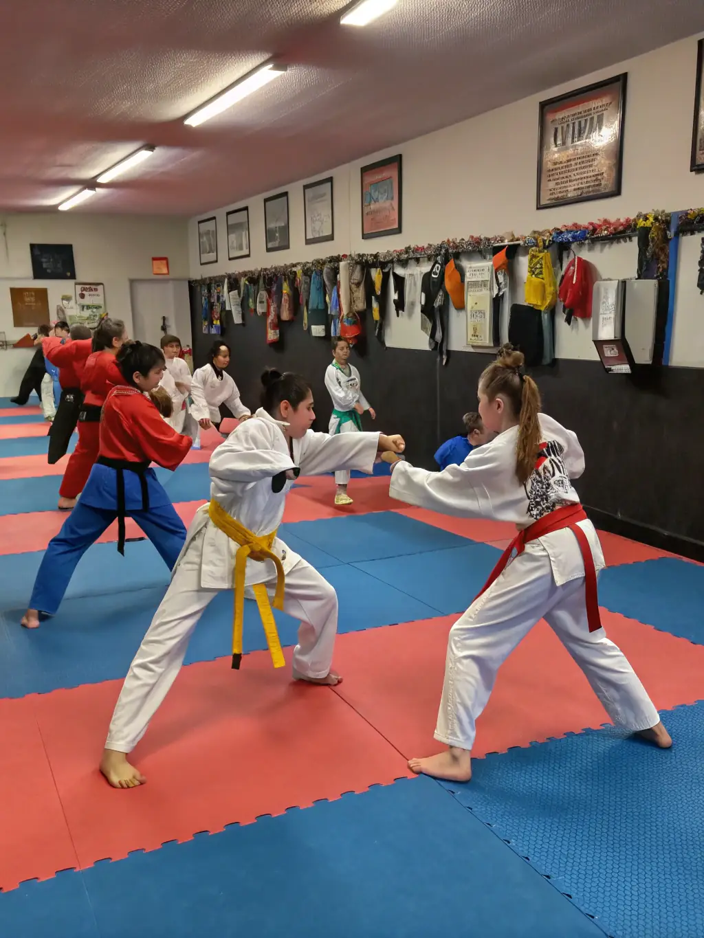 A group of Karate Club de Briançon members participating in a self-defense workshop, practicing practical techniques for real-world situations.